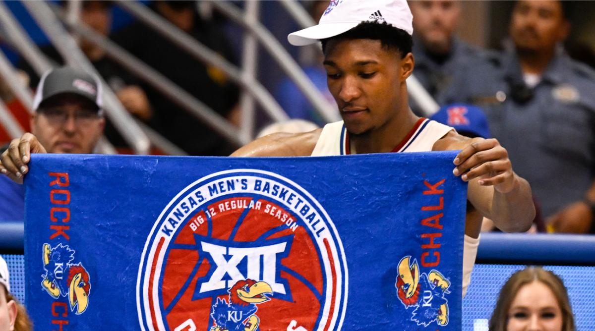 Kansas forward David McCormack holds up a banner celebrating their Big 12 Championship after defeating Texas in overtime in an NCAA college basketball game in Lawrence, Kan., Saturday, March 5, 2022.
