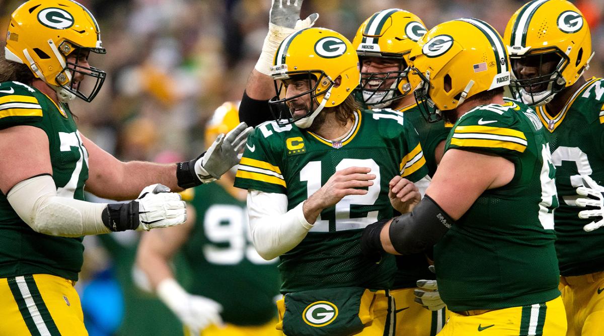 Green Bay Packers quarterback Aaron Rodgers (12) celebrates with teammates after completing a touchdown pass making him the all time leader in touchdown passes in the first quarter during their football game Saturday, December 25, 2021, at Lambeau Field in Green Bay, Wis.