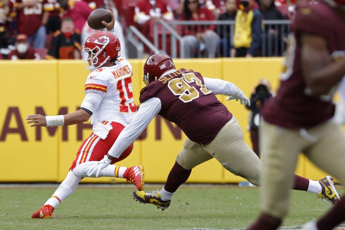 Kansas City Chiefs quarterback Patrick Mahomes (15) scrambles from Washington defensive tackle Tim Settle (97). Mandatory Credit: Geoff Burke-USA TODAY Sports