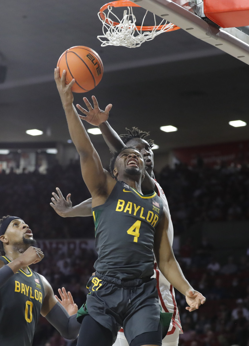 Jan 22, 2022; Norman, Oklahoma, USA; Baylor Bears guard LJ Cryer (4) goes up for a basket ahead of Oklahoma Sooners forward Akol Mawein (11) during the first half at Lloyd Noble Center. Mandatory Credit: Alonzo Adams-USA TODAY Sports