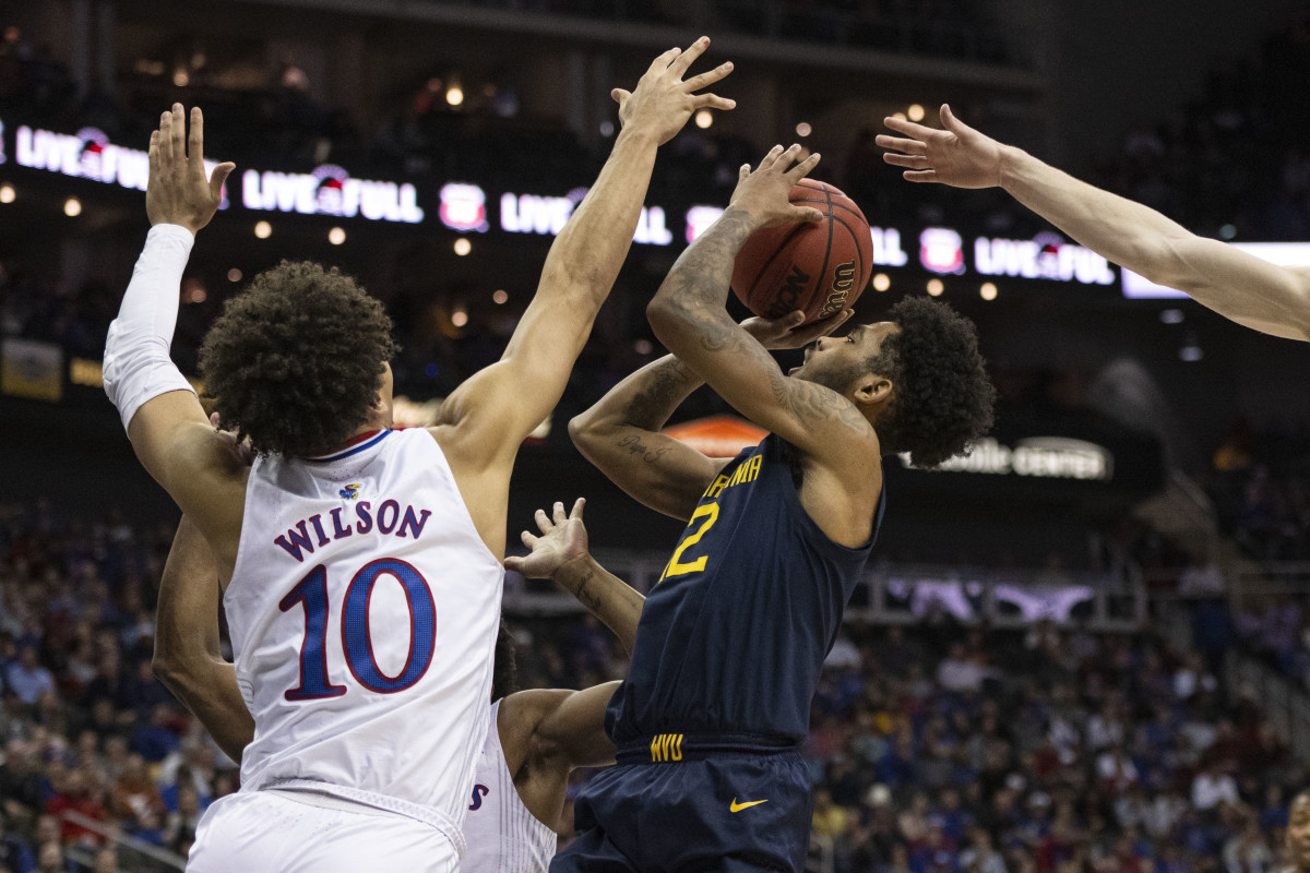 Mar 10, 2022; Kansas City, MO, USA; West Virginia Mountaineers guard Taz Sherman (12) shoots the ball while defended by Kansas Jayhawks forward Jalen Wilson (10) in the first half at T-Mobile Center. Mandatory Credit: Amy Kontras-USA TODAY Sports