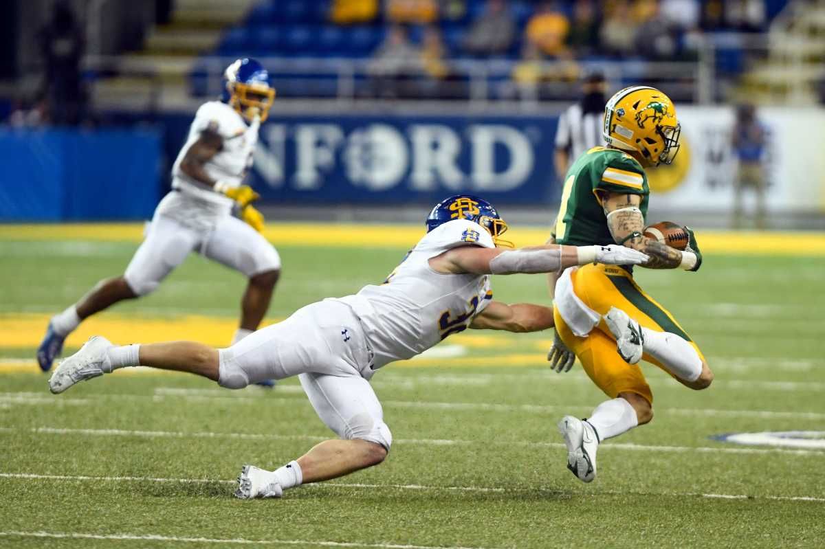 South Dakota State's Adam Bock tackles North Dakota State's Christian Watson during the Dakota Marker rivalry game on Saturday, April 17, 2021, at the Fargodome in Fargo. Dakota Marker 005