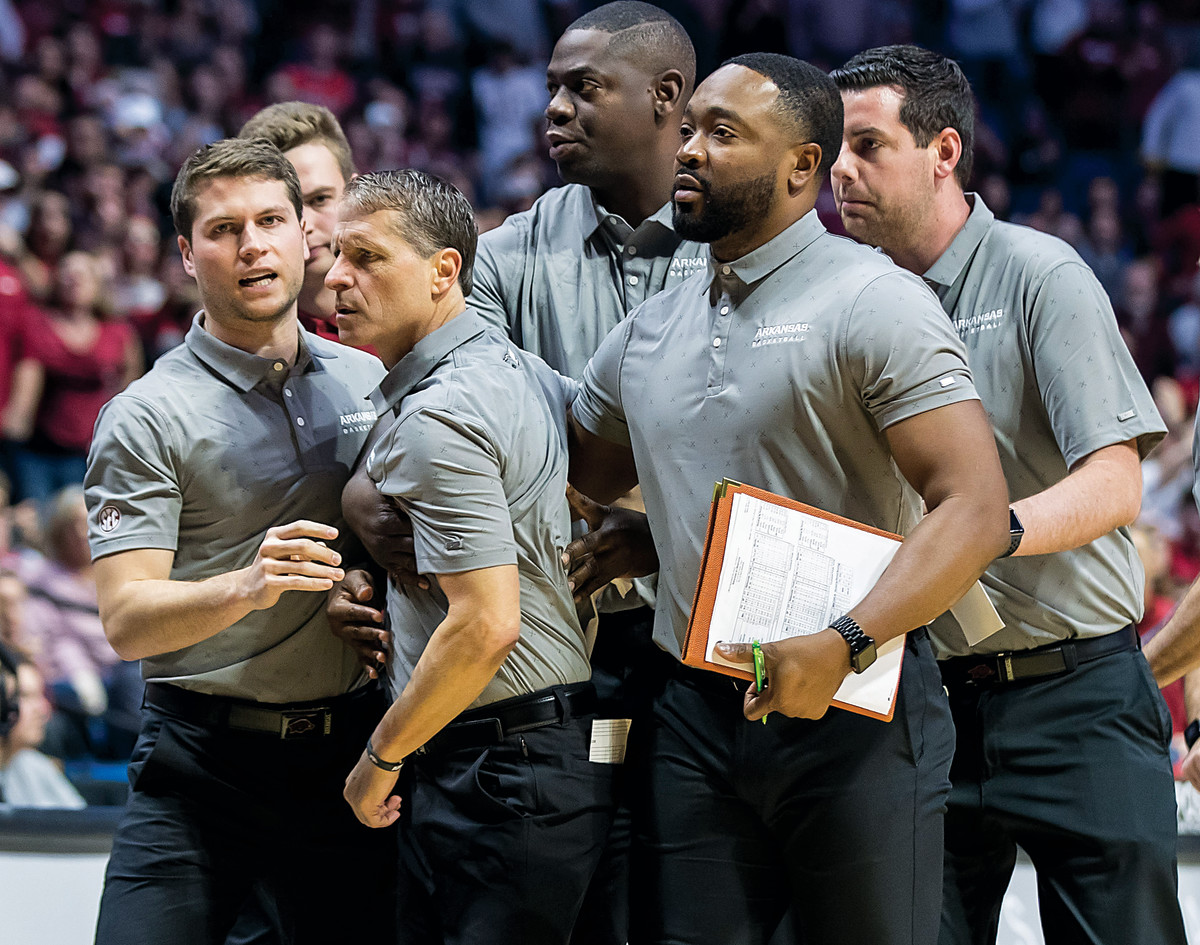 Arkansas head coach Eric Musselman has to be held back after losing his cool during an early-start blowout against Oklahoma.