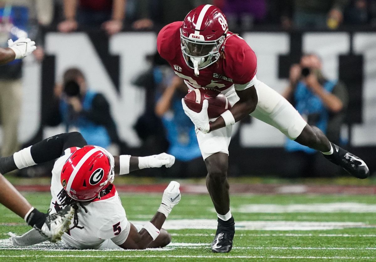 Alabama wide receiver Agiye Hall (84) breaks the tackle of Georgia Bulldogs defensive back Kelee Ringo (5) during the 2022 CFP college football national championship game at Lucas Oil Stadium.