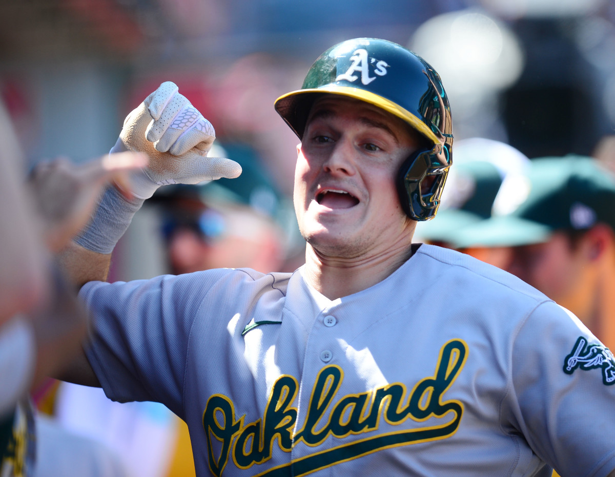Former Oakland third baseman celebrates in A's dugout.