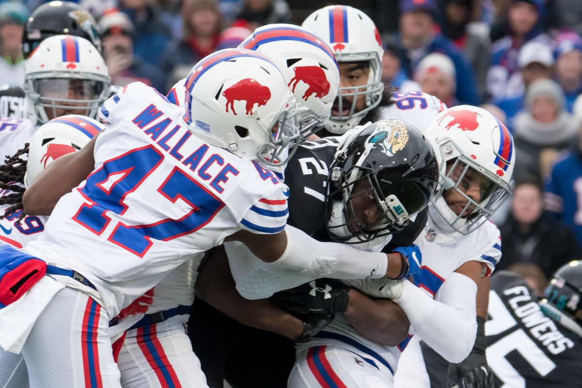 Jacksonville Jaguars running back Leonard Fournette (27) is tackled by Buffalo Bills strong safety Micah Hyde (right), defensive back Levi Wallace (47) and other defenders during the first quarter at New Era Field.