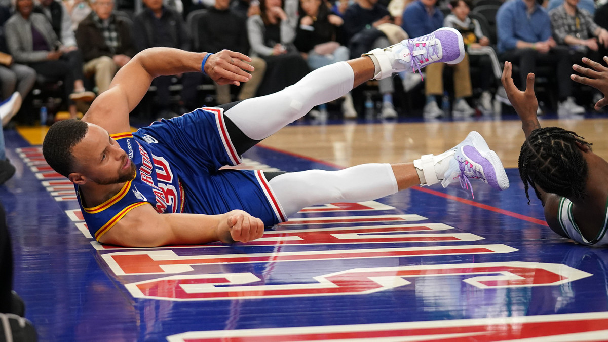 Warriors guard Stephen Curry (30) falls on the ground after being called for an offensive foul against the Boston Celtics