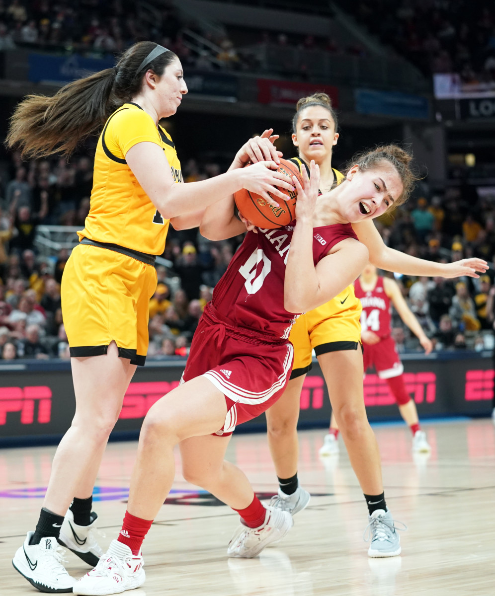 Aleksa Gulbe holds onto the ball away from Iowa defenders.