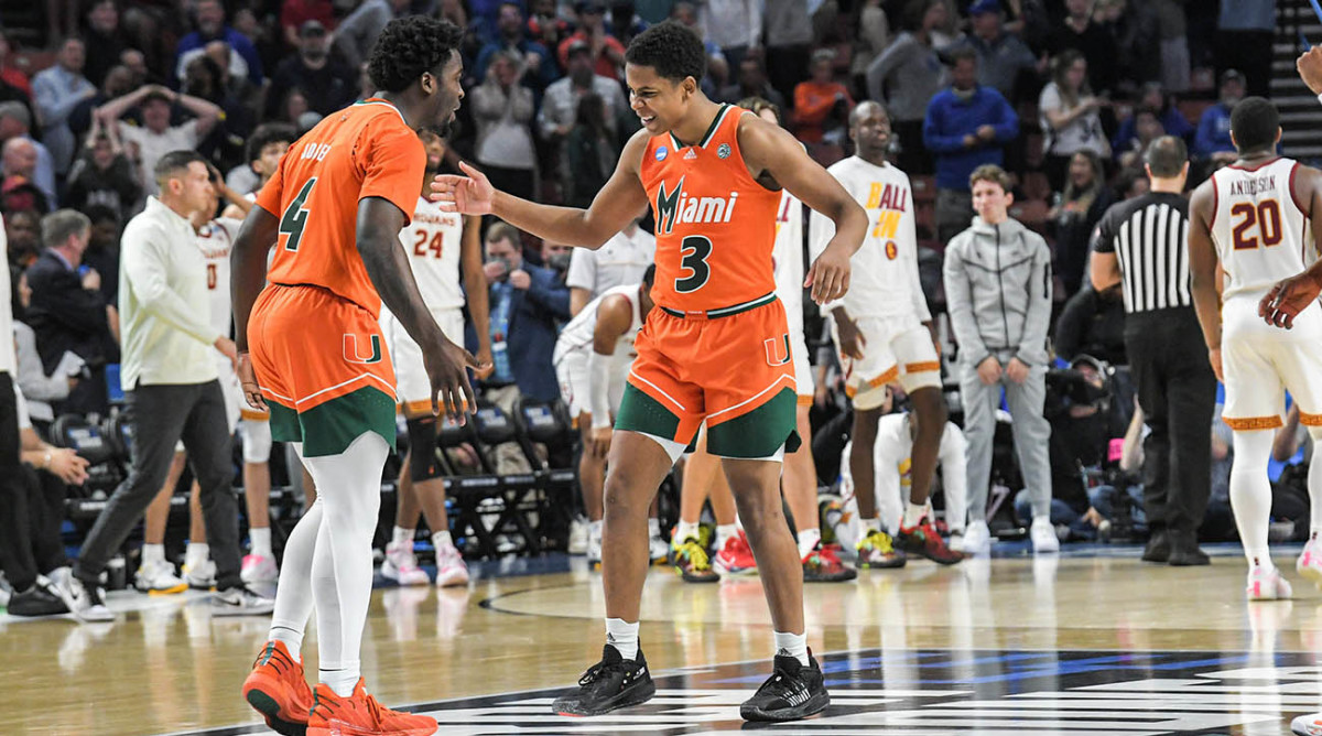 Miami guard Beesley Joseph (4) and guard Charlie Moore (3) celebrate after helping beat University of Southern California 68–66 at the NCAA tournament.