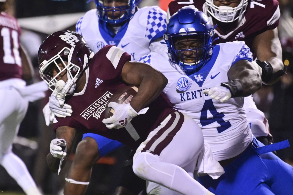Oct 30, 2021; Starkville, Mississippi, USA; Mississippi State Bulldogs running back Jo'quavious Marks (7) runs the ball while defended by Kentucky Wildcats defensive end Josh Paschal (4) during the second quarter at Davis Wade Stadium at Scott Field.