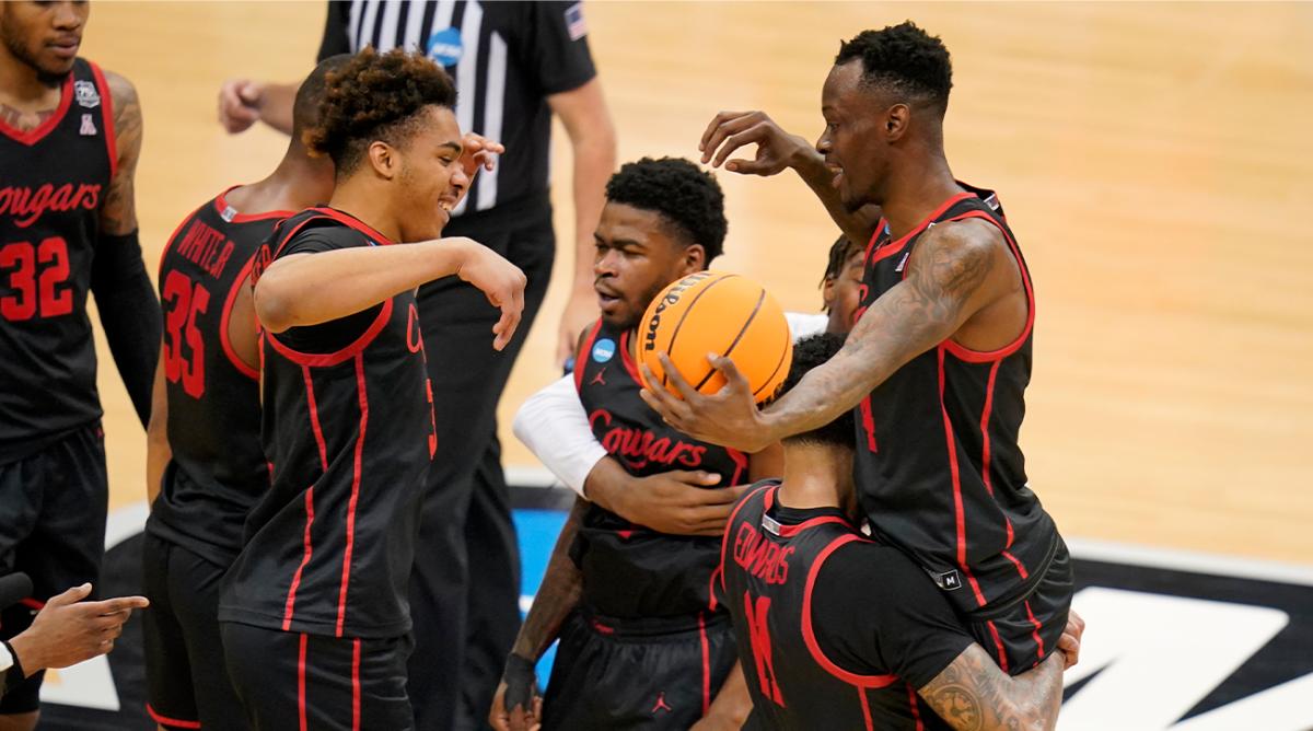 Houston ‘s Taze Moore, top right, is hoisted by Kyler Edwards (11) as they celebrate a 68-53 win over Illinois in a college basketball game in the second round of the NCAA tournament in Pittsburgh, Sunday, March 20, 2022.