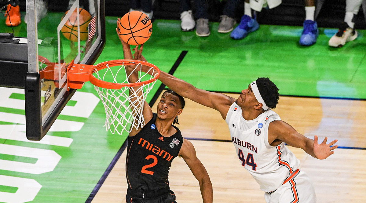 University of Miami guard Isaiah Wong (2) scores near Auburn University center Dylan Cardwell (44) during the first half of the NCAA men's tournament preliminary round game at Bon Secours Wellness Arena.