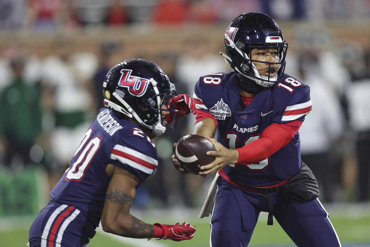 Dec 18, 2021; Mobile, Alabama, USA; Liberty Flames quarterback Kaidon Salter (18) hands off to running back Troy Henderson (20) against the Eastern Michigan Eagles in the fourth quarter during the 2021 LendingTree Bowl at Hancock Whitney Stadium. Mandatory Credit: Robert McDuffie-USA TODAY Sports