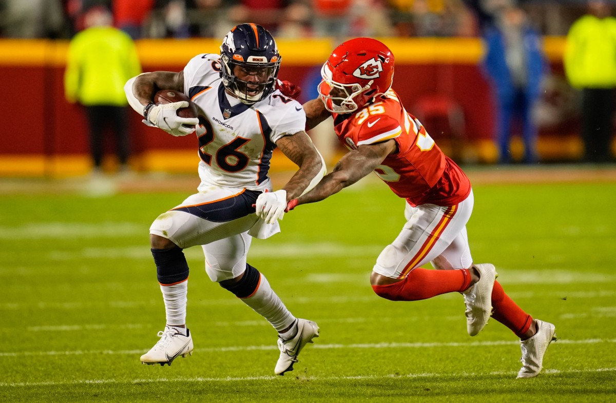 Denver Broncos running back Mike Boone (26) runs the ball against Kansas City Chiefs cornerback Charvarius Ward (35) during the second half at GEHA Field at Arrowhead Stadium.