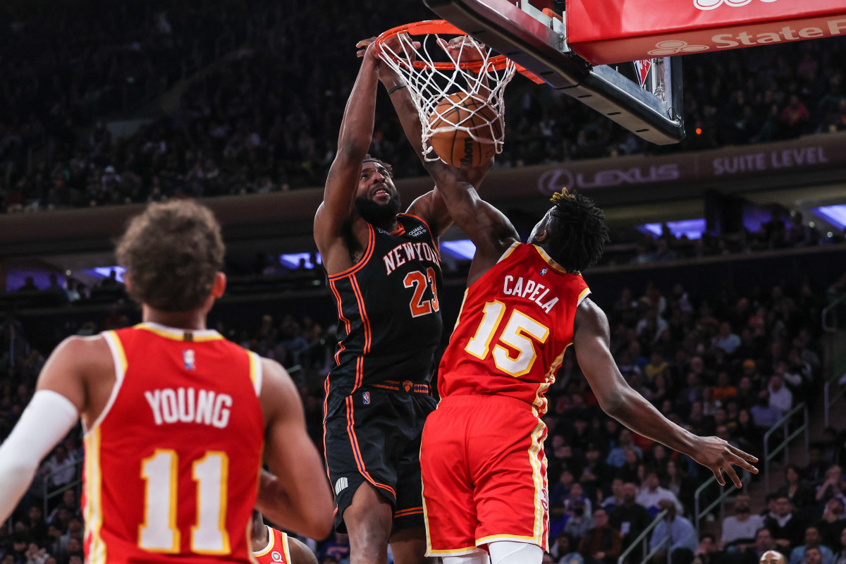 Mar 22, 2022; New York, New York, USA; New York Knicks center Mitchell Robinson (23) dunks as Atlanta Hawks center Clint Capela (15) defends during the second half at Madison Square Garden.