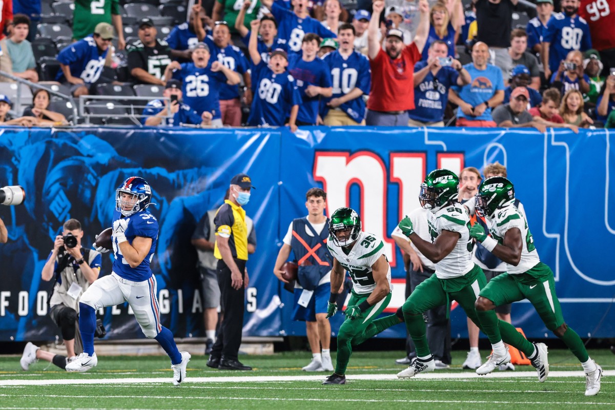 Aug 14, 2021; East Rutherford, New Jersey, USA; New York Giants running back Sandro Platzgummer (34) carries the ball against New York Jets defensive back Sharrod Neasman (35) and defensive end Carl Lawson (58) during the second half at MetLife Stadium.
