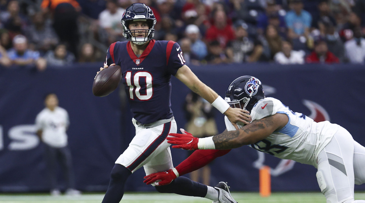 Houston Texans quarterback Davis Mills (10) runs with the ball as Tennessee Titans defensive end Jeffery Simmons (98) attempts to make a tackle during the first quarter at NRG Stadium.