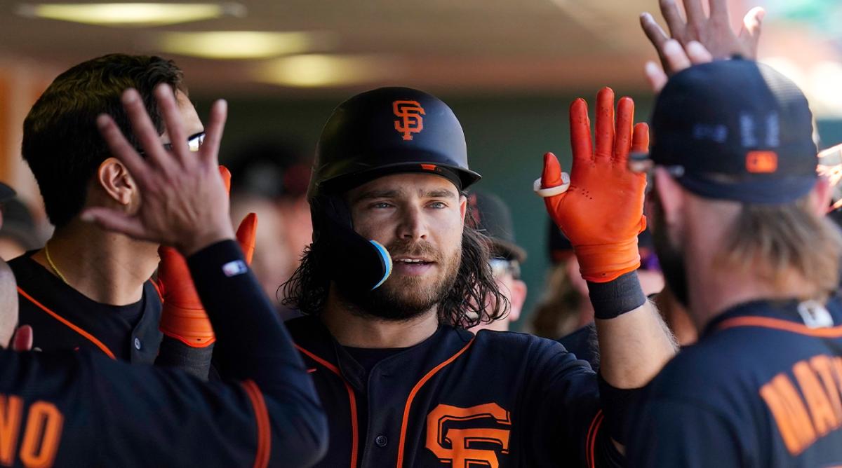 San Francisco Giants’ Brandon Crawford is congratulated in the dugout for his home run against the Colorado Rockies during the first inning of a spring training baseball game Thursday, March 31, 2022, in Scottsdale, Ariz.