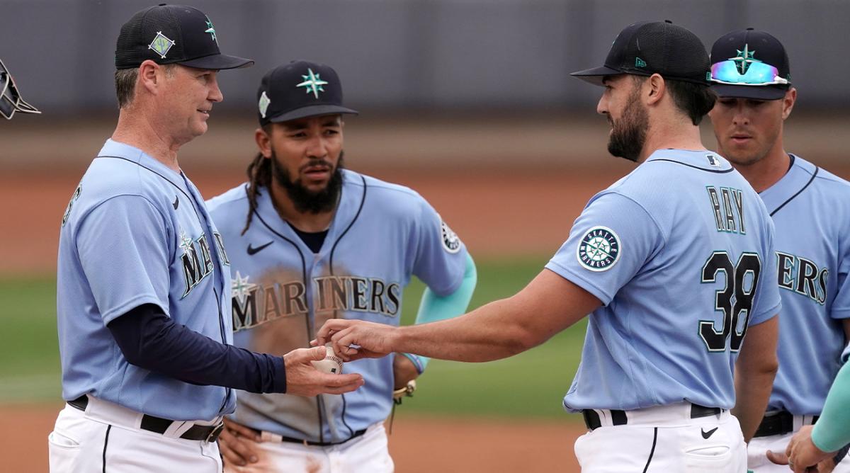 Seattle Mariners manager Scott Servais, left, takes the ball from starting pitcher Robbie Ray (38) after making a pitching change during the fifth inning of a spring training baseball game against the Texas Rangers Monday, March 28, 2022, in Peoria, Ariz.