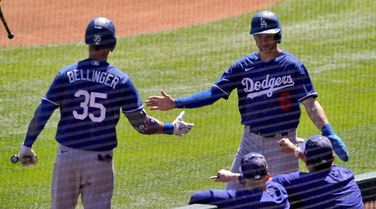 Los Angeles Dodgers’ Trea Turner greets Cody Bellinger (35) after scoring on a base hit by Freddie Freeman during the first inning of a spring training baseball game against the Colorado Rockies, Thursday, March 24, 2022, in Scottsdale, Ariz.