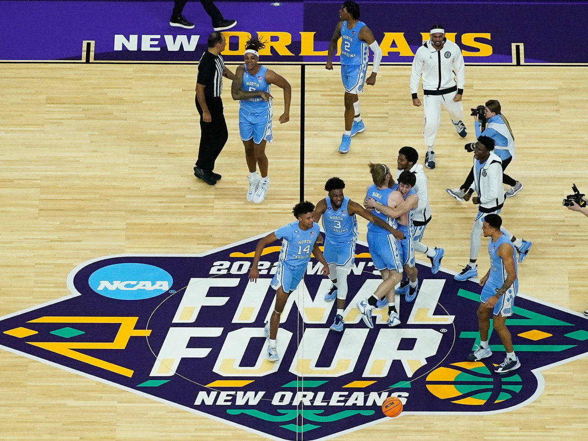 UNC players celebrate on the court after beating Duke