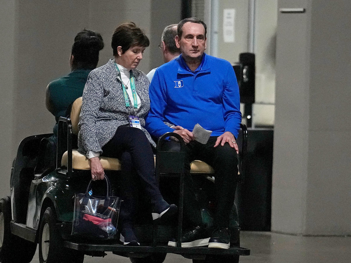 Coach K (right) and his wife Mickie ride off on a golf cart