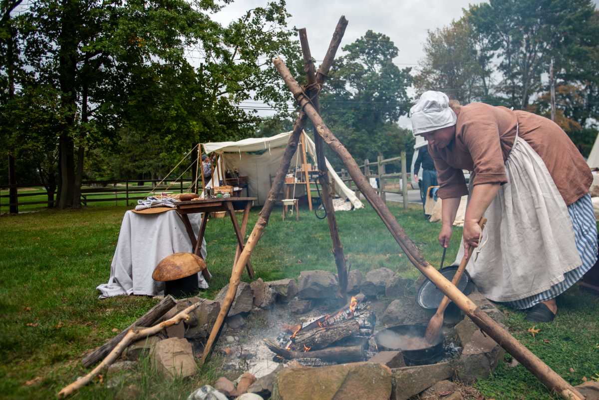 The Encampment at Dey Mansion in Wayne, NJ shows visitors what life was like during the American Revolution. Drea Hahn, with the Second New Jersey Regiment, Helm's Company, cooks over an open fire on Saturday October 09, 2021. 5th Annual Paws In The Park