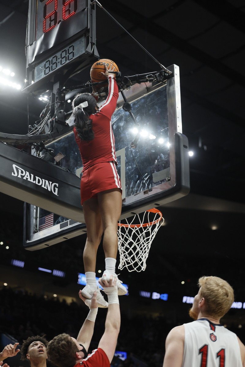 Indiana cheerleaders Cassidy Cerny and Nathan Paris come to the rescue to dislodge a basketball stuck on top of the backboard during the Hoosiers' NCAA Tournament game against Saint Mary's in Portland, Ore. (Soobum Im-USA TODAY Sports)