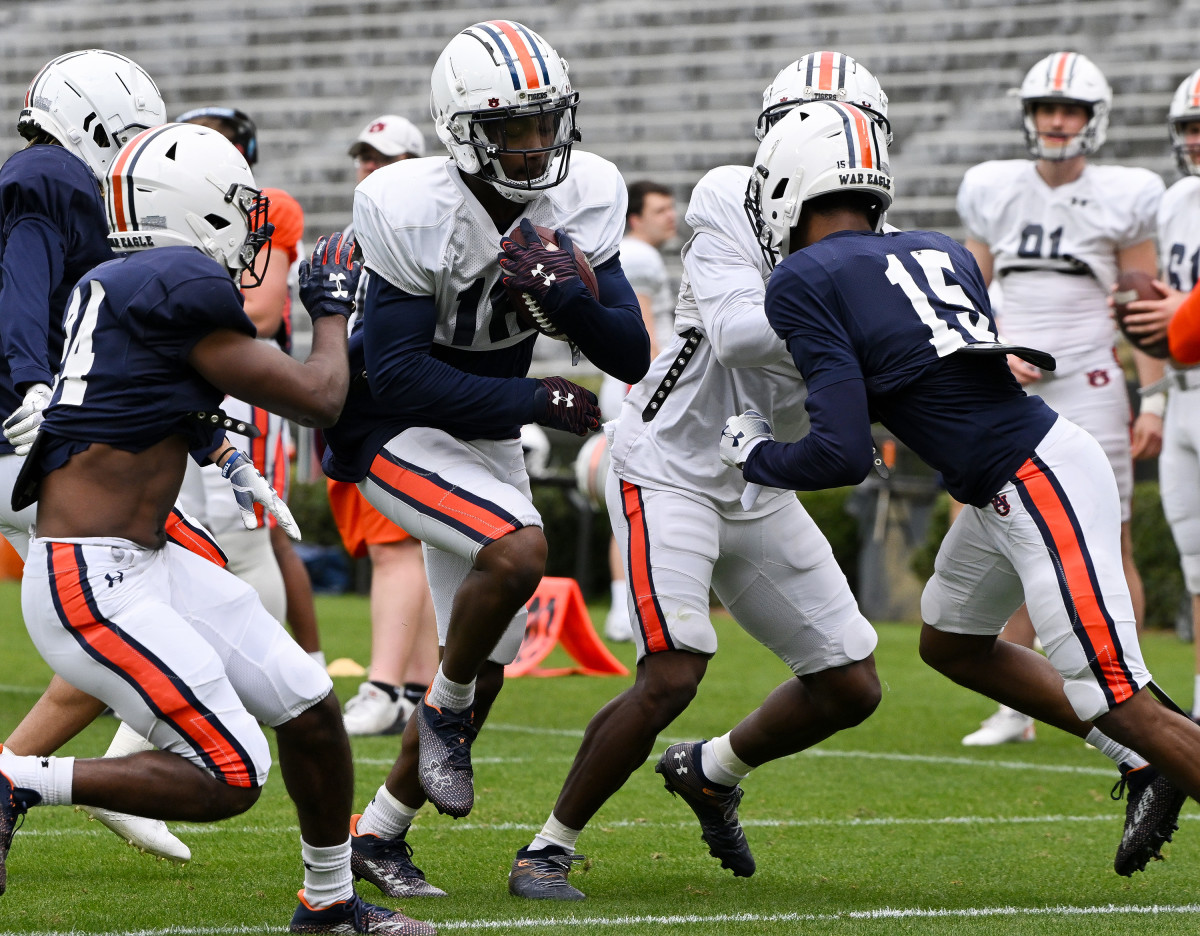 Malcolm Johnson Jr. (16) runs after a catch while defenders Tony Hunley Jr. (240 and A.D. Diamond (15) close in.Auburn FB scrimmage on Saturday, April 2, 2022 in Auburn, Ala.