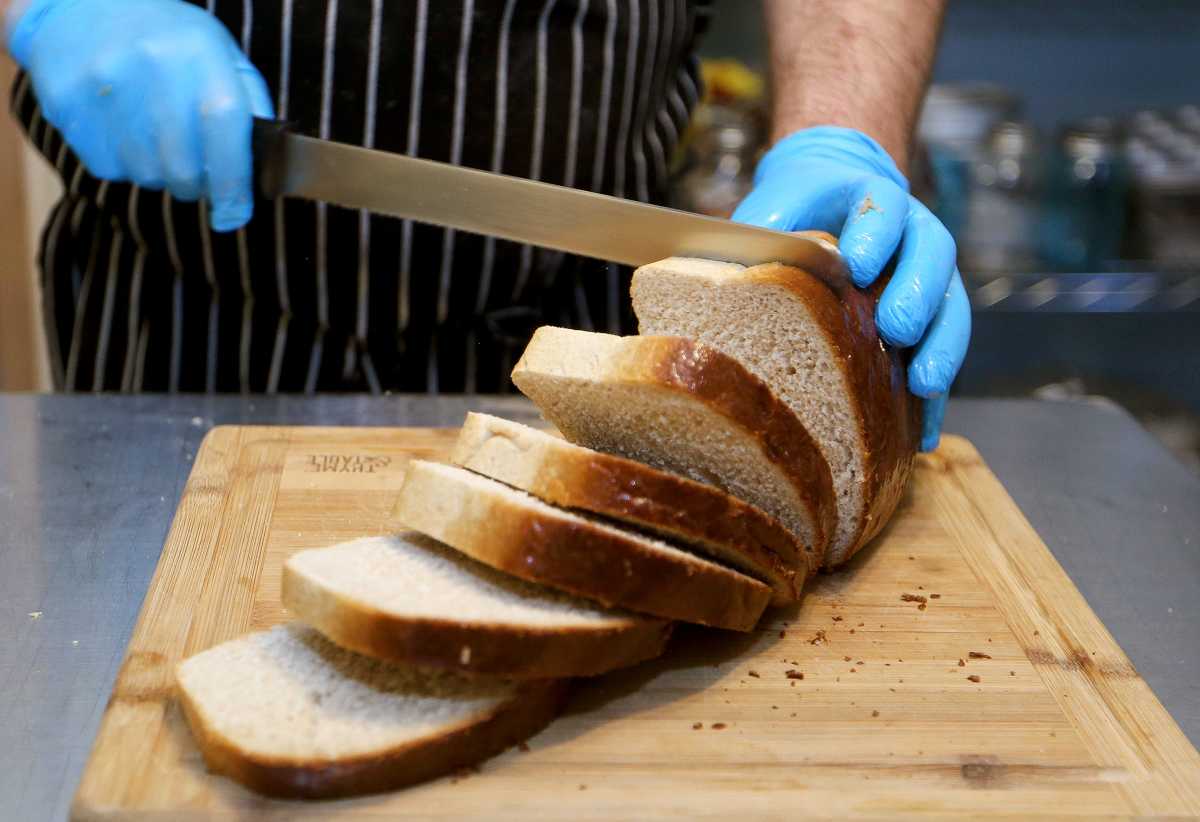 Ben Wallace cuts a loaf of homemade bread at his Triple B's Bakery in Nickerson. Wallace said that his family, his mother and grandmother, helped him with his love of good food. Hut 011922 Triple B Bakery 02