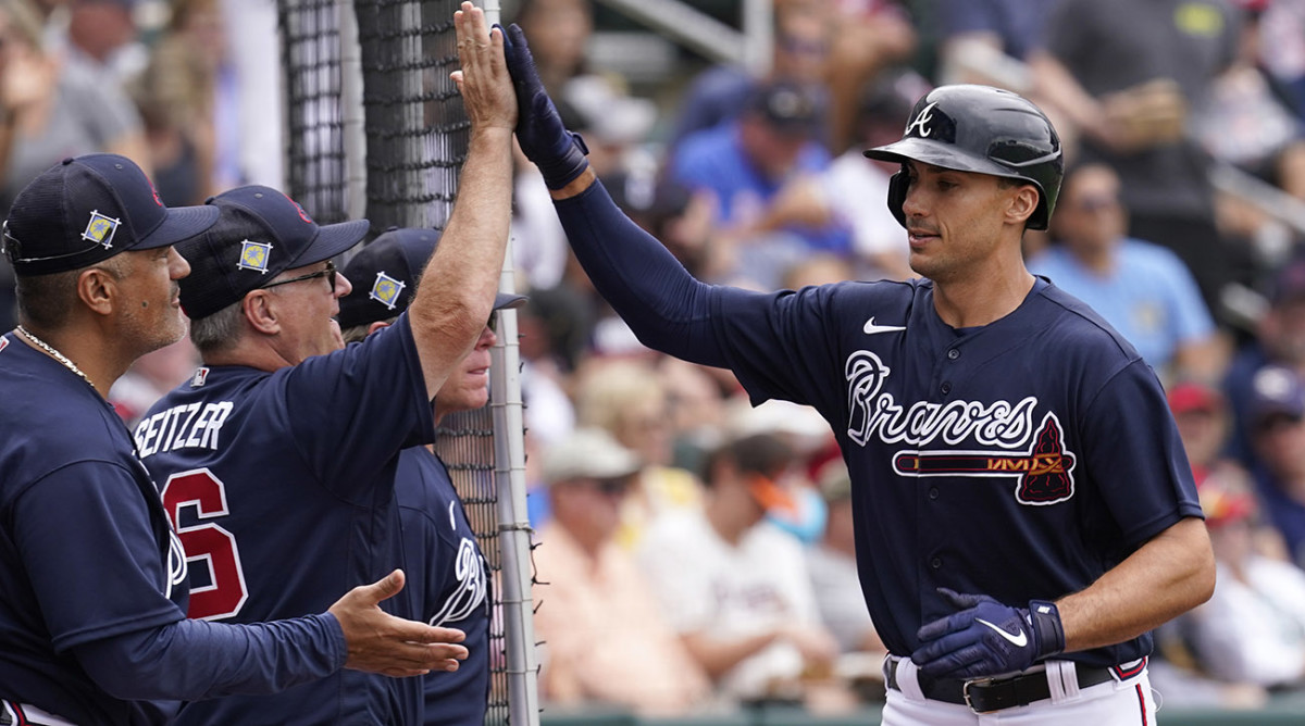 Braves hitting coach Kevin Seitzer, left, gets a high five from first baseman Matt Olson, right, after Olson's solo home run in the first inning during spring training baseball game against the Boston Red Sox at CoolToday Park
