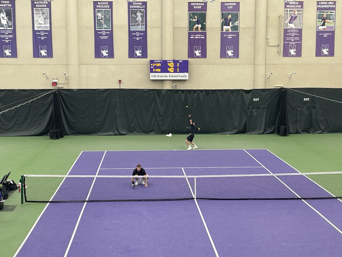 (Natan Spear, near, and Trice Pickens, far, serve to Michigan State on a winner-take-all point during their doubles match. Ross Shinberg / Wildcats Daily)