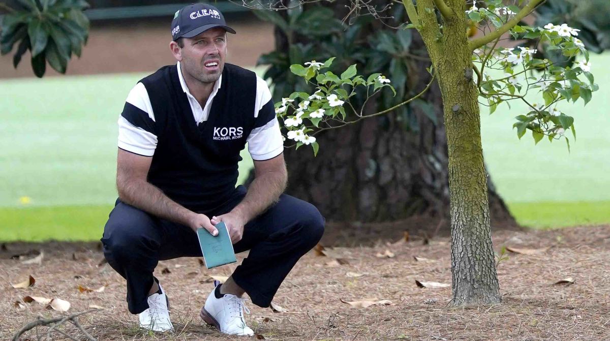 Charl Schwartzel sizes up a shot from the pine straw during the second round of the 2022 Masters.