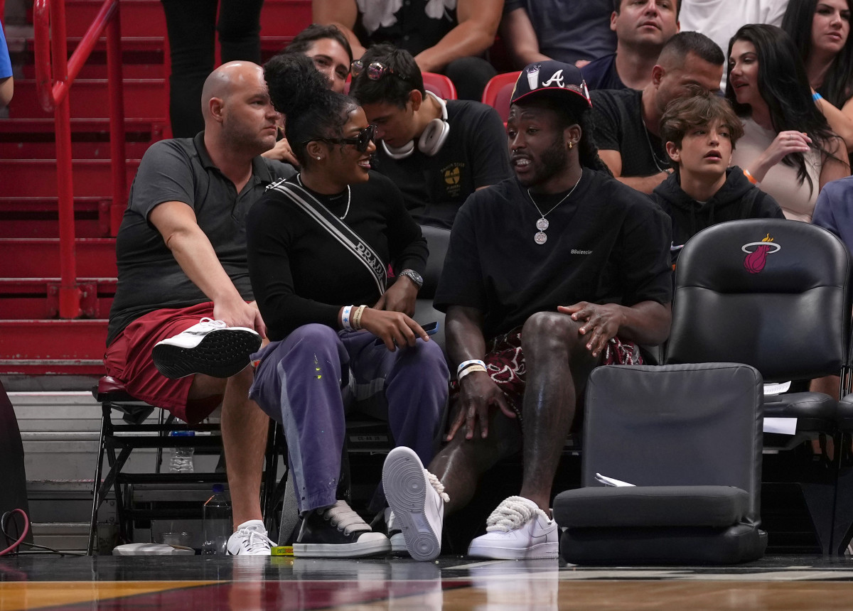 Apr 8, 2022; Miami, Florida, USA; New Orleans Saints running back Alvin Kamara (R) sits with girlfriend WNBA star Te a Cooper (L) during the second half between the Miami Heat and the Atlanta Hawks at FTX Arena.