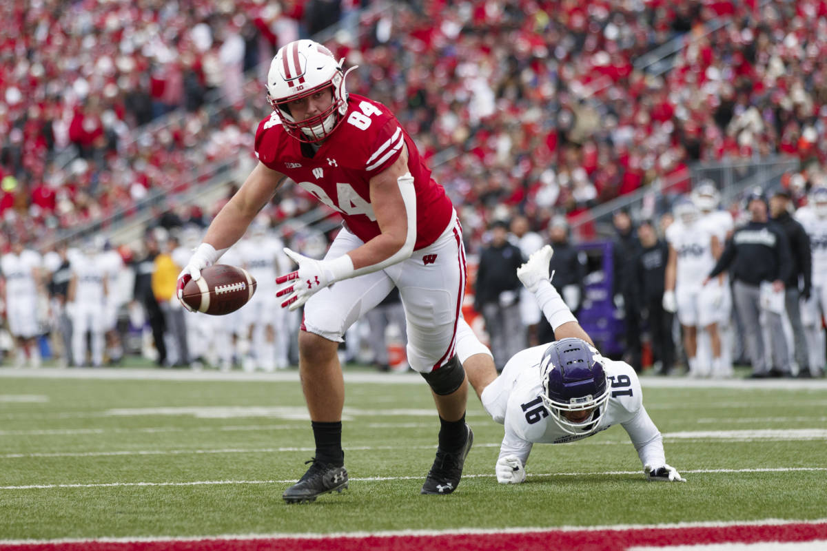Nov 13, 2021; Madison, Wisconsin, USA; Wisconsin Badgers tight end Jake Ferguson (84) scores a touchdown in front of Northwestern Wildcats safety Brandon Joseph (16) during the third quarter at Camp Randall Stadium. Mandatory Credit: Jeff Hanisch-USA TODAY Sports