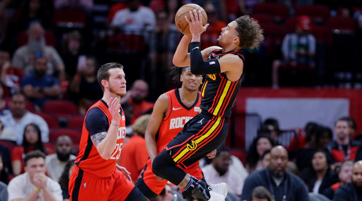 Atlanta Hawks guard Trae Young, right, puts up a shot over Houston Rockets guards Garrison Mathews (25) and Jalen Green, back, during the second half of an NBA basketball game Sunday, April 10, 2022, in Houston.