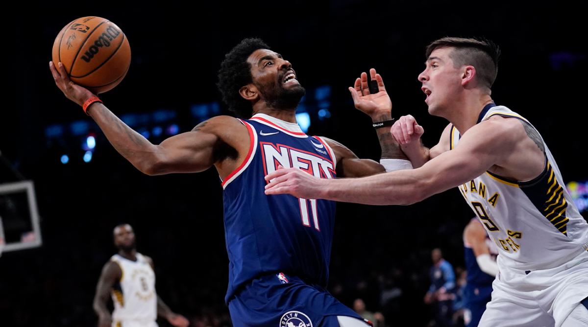 Brooklyn Nets’ Kyrie Irving, left, drives to the basket while Indiana Pacers’ T.J. McConnell defends during the second half of an NBA basketball game at the Barclays Center, Sunday, Apr. 10, 2022, in New York. The Nets defeated the Pacers 134-126.