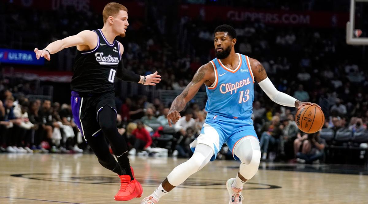 Los Angeles Clippers guard Paul George (13) is defended by Sacramento Kings guard Donte DiVincenzo (0) during the first half of an NBA basketball game Saturday, April 9, 2022, in Los Angeles.