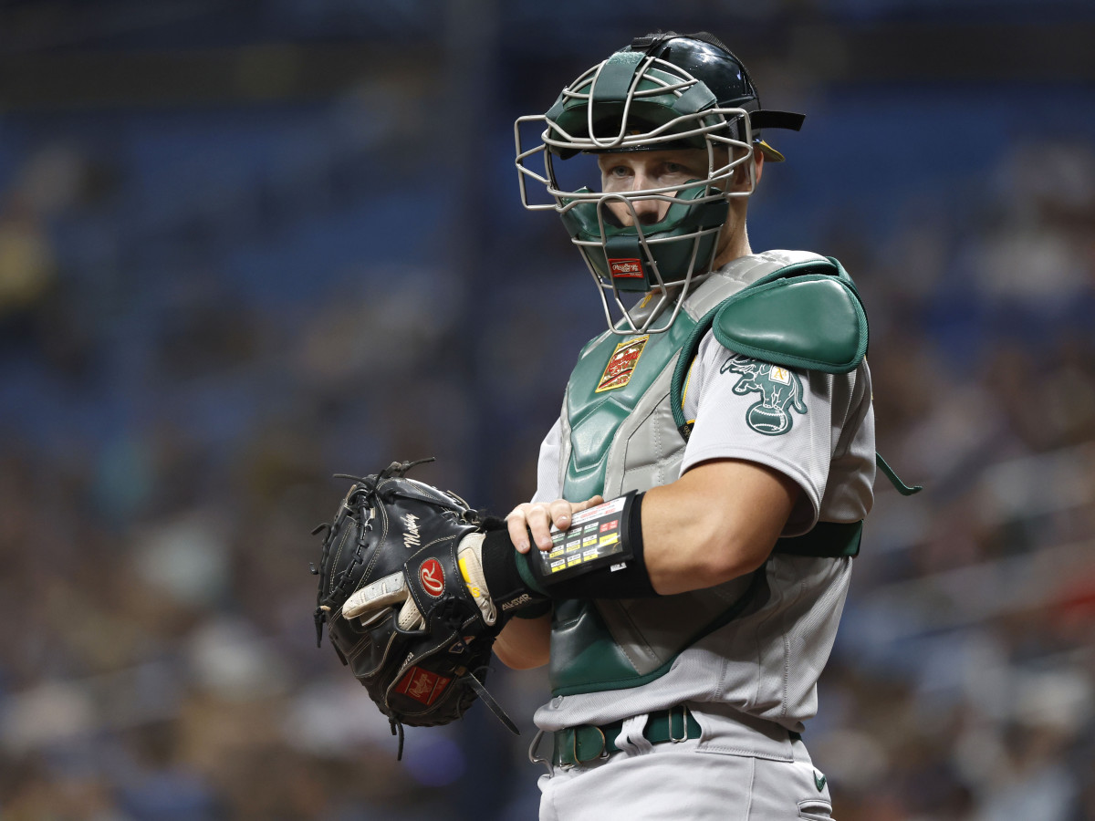 Apr 11, 2022; St. Petersburg, Florida, USA; Oakland Athletics catcher Sean Murphy (12) presses a button on his wristband and it sends a signal to a receiver in the pitcher’s hat, which then speaks to the pitcher and tells them what pitch to throw, during the first inning at Tropicana Field.