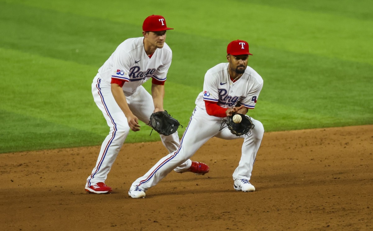 Apr 12, 2022; Arlington, Texas, USA; Texas Rangers second baseman Marcus Semien (2) fields a ground ball in front of Texas Rangers shortstop Corey Seager (5) during the fifth inning against the Colorado Rockies at Globe Life Field. Mandatory Credit: Kevin Jairaj-USA TODAY Sports