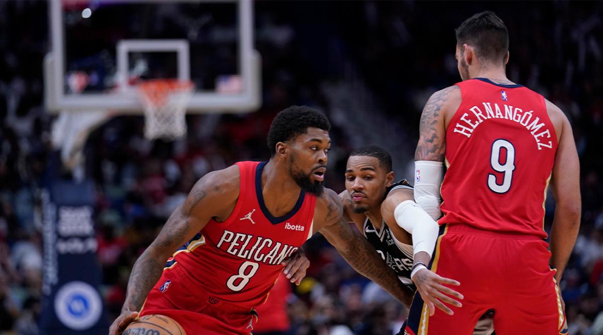 New Orleans Pelicans center Willy Hernangomez (9) throws a pick against San Antonio Spurs guard Dejounte Murray as Pelicans forward Naji Marshall (8) drives to the basket in the second half of an NBA basketball game in New Orleans, Saturday, March 26, 2022. The Spurs won 107-103.