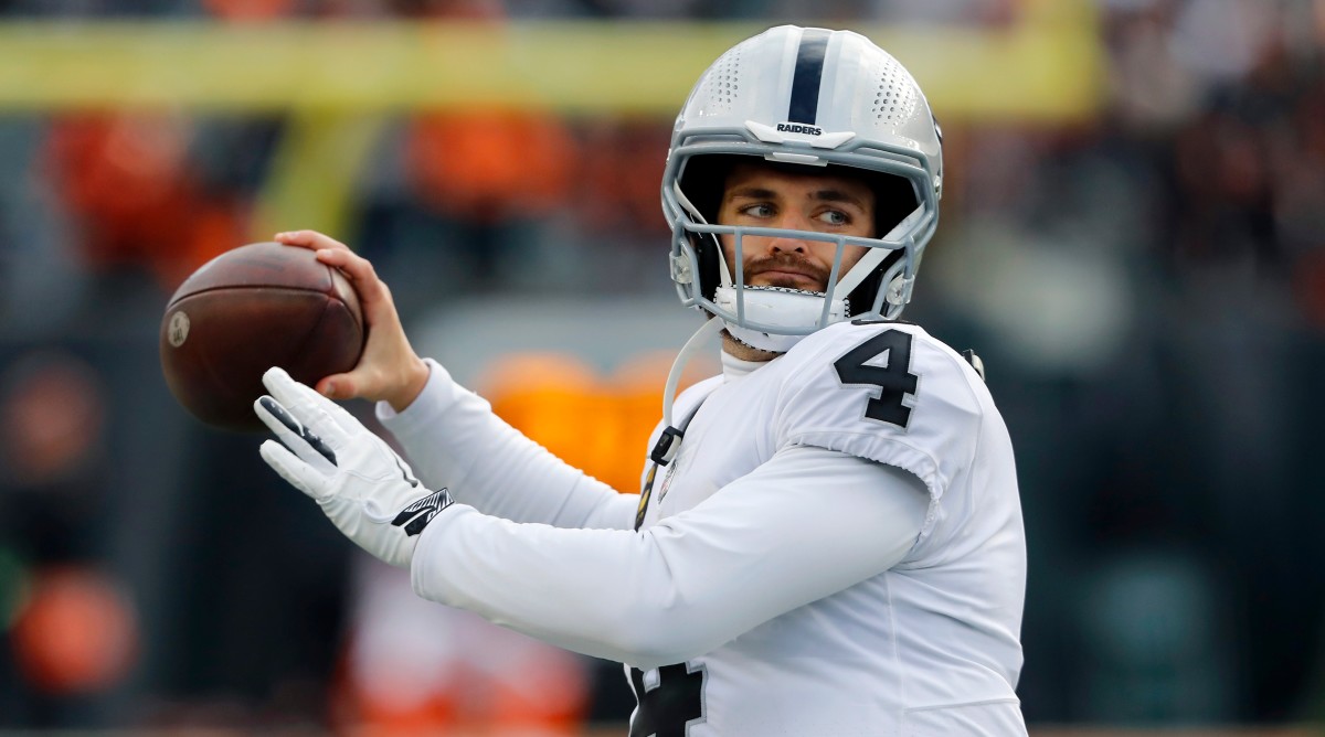 Derek Carr warms up before a game by throwing a pass.