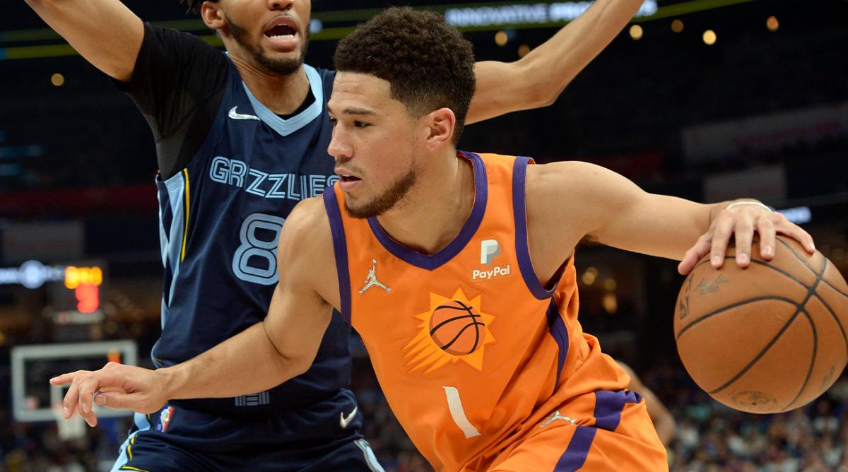 Phoenix Suns guard Devin Booker (1) handles the ball against Memphis Grizzlies guard Ziaire Williams (8) in the first half of an NBA basketball game Friday, April 1, 2022, in Memphis, Tenn.