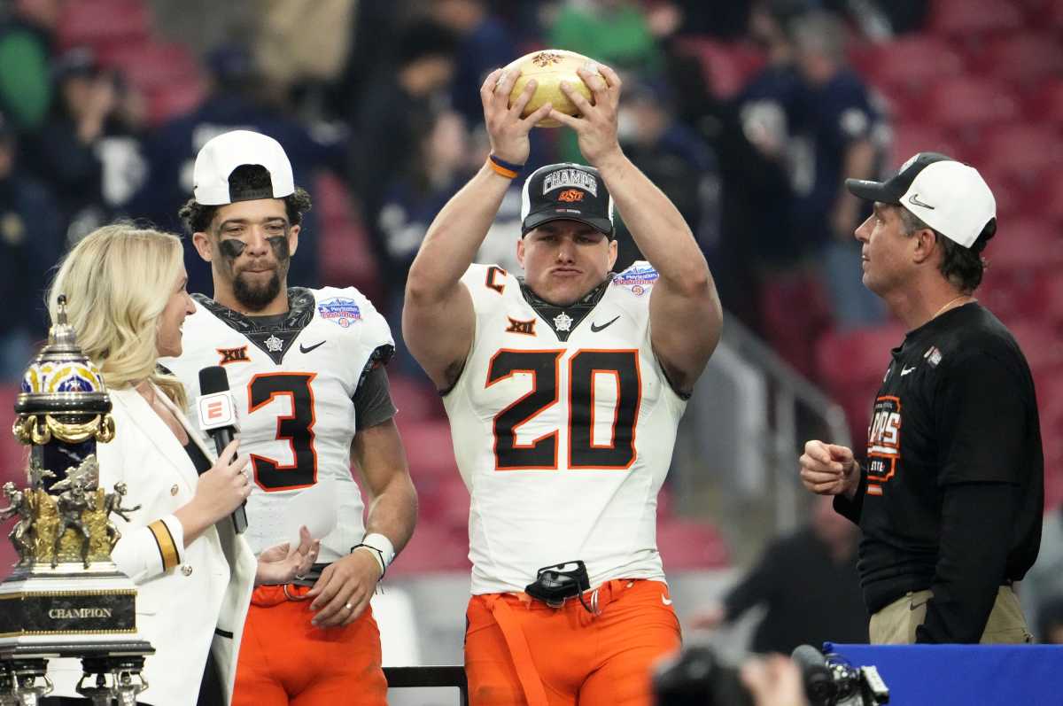 Jan 1, 2022; Glendale, Arizona, USA; Oklahoma State quarterback Spencer Sanders (3), linebacker Malcolm Rodriguez (20) and head coach Mike Gundy celebrate with the trophy after defeating Notre Dame in the PlayStation Fiesta Bowl at State Farm Stadium. Mandatory Credit: Rob Schumacher-Arizona Republic Ncaa Football Playstation Fiesta Bowl Oklahoma State At Notre Dame
