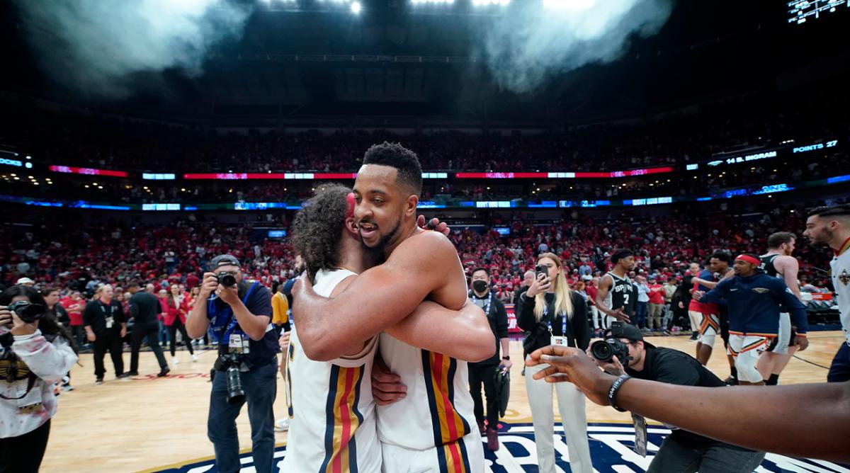 New Orleans Pelicans guard CJ McCollum, right, hugs guard Jose Alvarado after defeating the San Antonio Spurs in an NBA play-in basketball game in New Orleans, Wednesday, April 13, 2022. The Pelicans won 113-103.