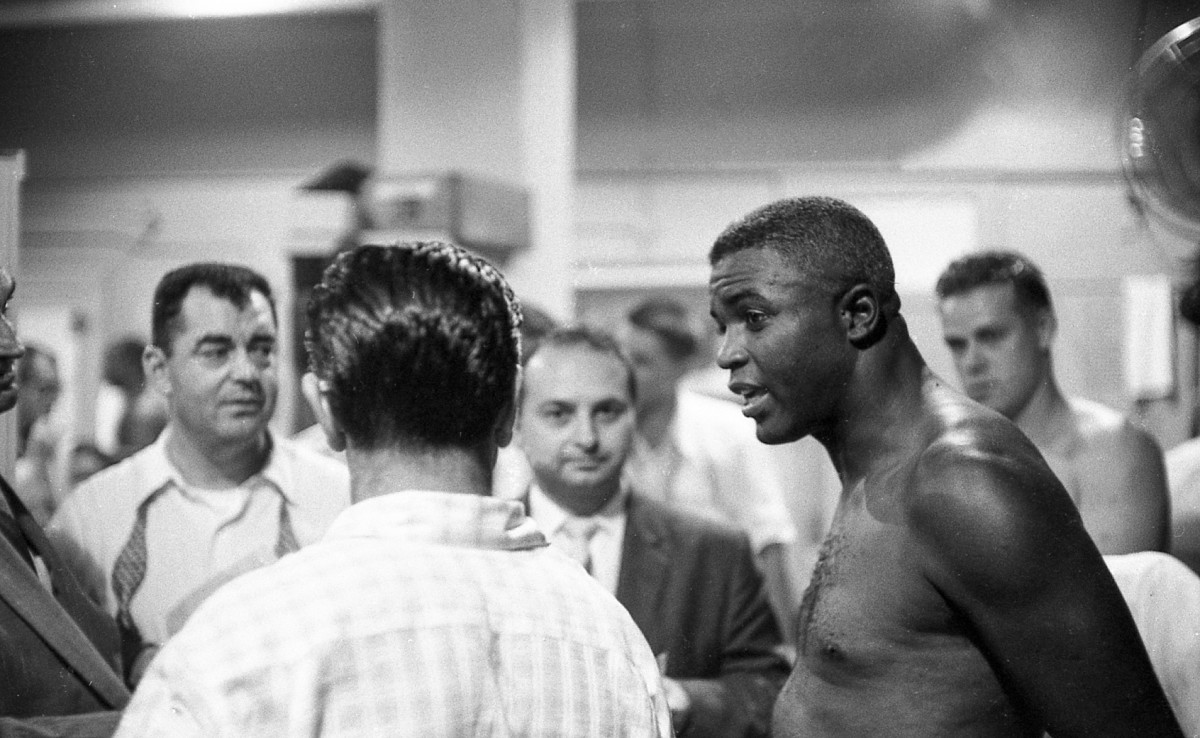 Brooklyn Dodgers second baseman Jackie Robinson (42) spoke with reporters in the locker room before a game against the Milwaukee Braves on Thursday, August 2, 1956, in Brooklyn, N.Y. Brooklyn defeated Milwaukee, 3-0.