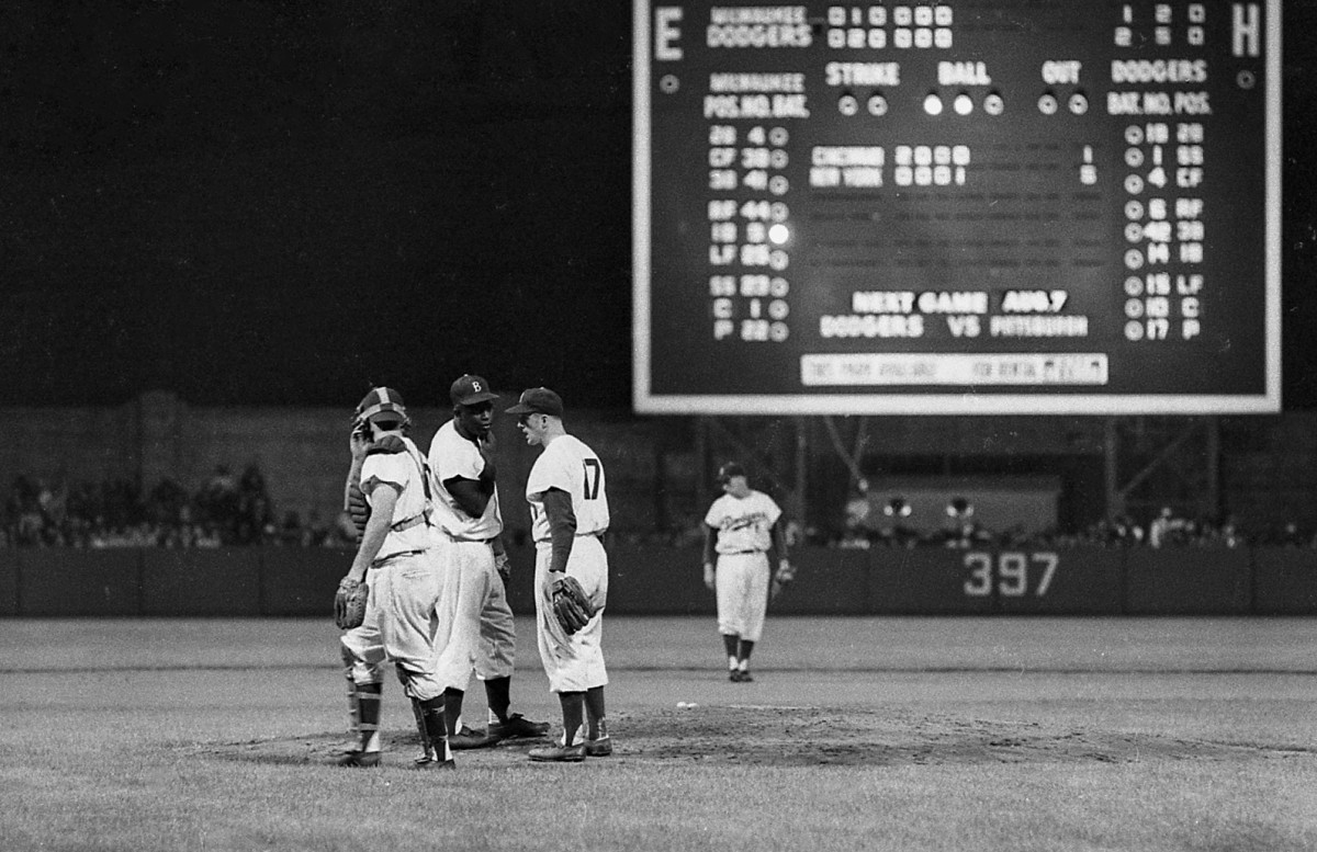 Brooklyn Dodgers second baseman Jackie Robinson (42) talks to right-handed pitcher Carl Erskine at the game against the Milwaukee Braves on Thursday, August 2, 1956, in Brooklyn, N.Y. Brooklyn defeated Milwaukee, 3-0.