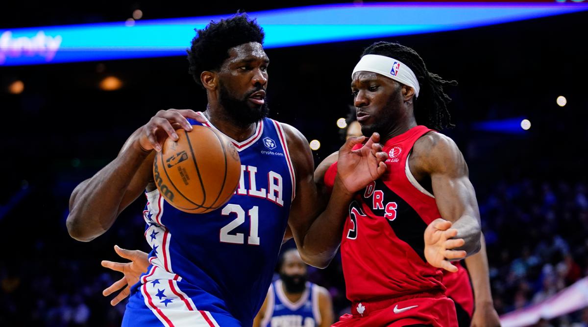 Philadelphia 76ers’ Joel Embiid, left, tries to get past Toronto Raptors’ Precious Achiuwa during the second half of an NBA basketball game, Sunday, March 20, 2022, in Philadelphia.