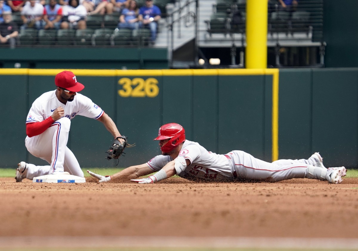 Apr 17, 2022; Arlington, Texas, USA; Los Angeles Angels center fielder Mike Trout (27) slides under the tag of Texas Rangers second baseman Marcus Semien (2) with an RBI double during the fourth inning at Globe Life Field. Mandatory Credit: Raymond Carlin III-USA TODAY Sports