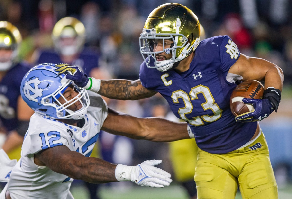 Notre Dame s Kyren Williams (23) pushes off North Carolina's Tomon Fox (12) before setting off on a long touchdown run during the Notre Dame 44-34 win over North Carolina in an NCAA college football game on Saturday, Oct. 30, 2021, in South Bend. Notre Dame Beats North Carolina